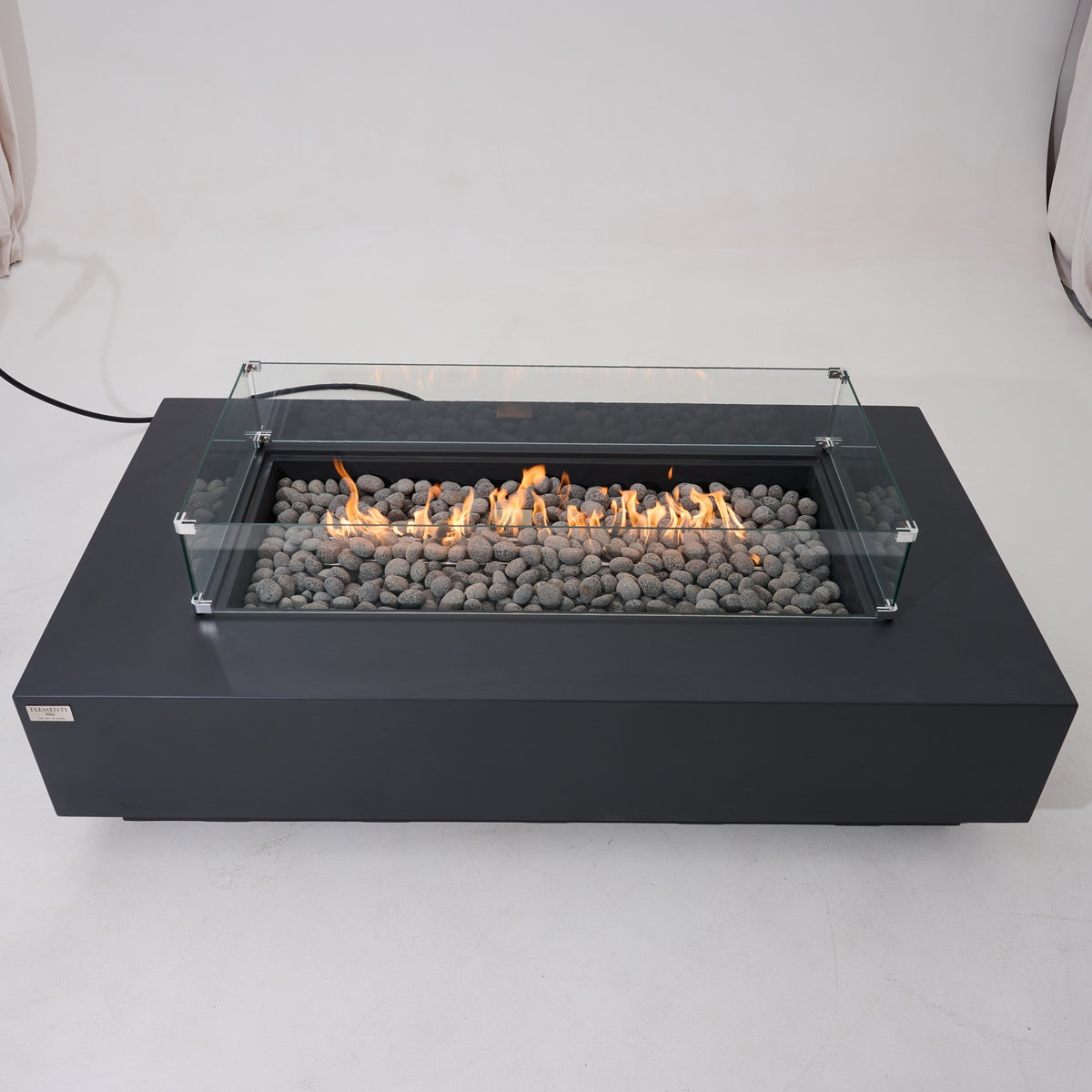 Elementi Pro Ravello 72-inch rectangle fire pit, Dark Gray – front view with glass wind guard, lit