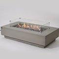 Elementi Pro Ravello 72-inch rectangle fire pit, Light Gray – angled view with glass wind guard, lit