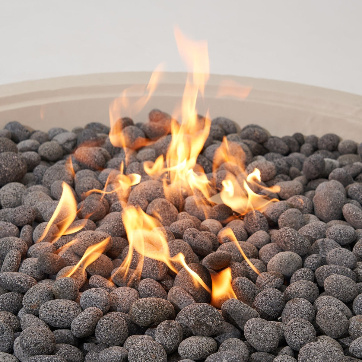 Elementi Pro Rose Bowl 48-inch 100K BTU fire pit, Frosted Cream White – close-up of flames over lava rock