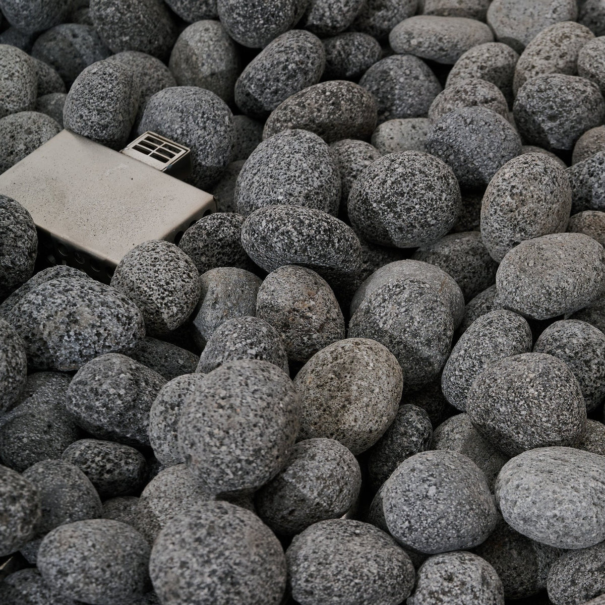 Elementi Pro Rose Bowl 48-inch 100K BTU fire pit, Moon Gray – burner and lava rock close-up